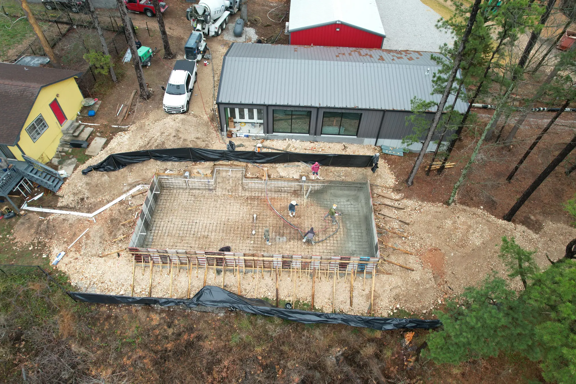 Aerial view of pool construction and steel rebar at a hillside home in Northwest Arkansas