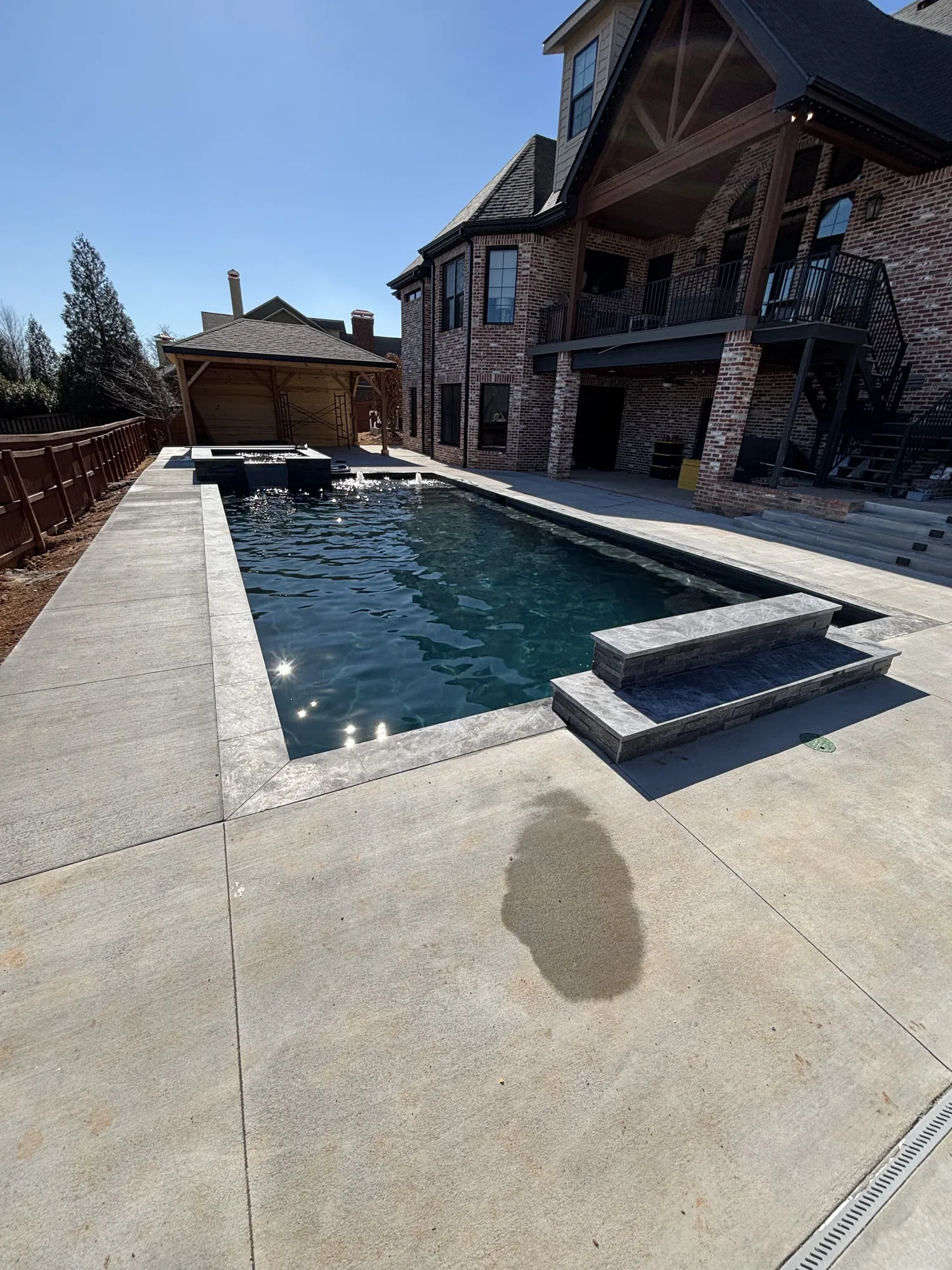 Finished pool and spa at brick home in Northwest Arkansas
