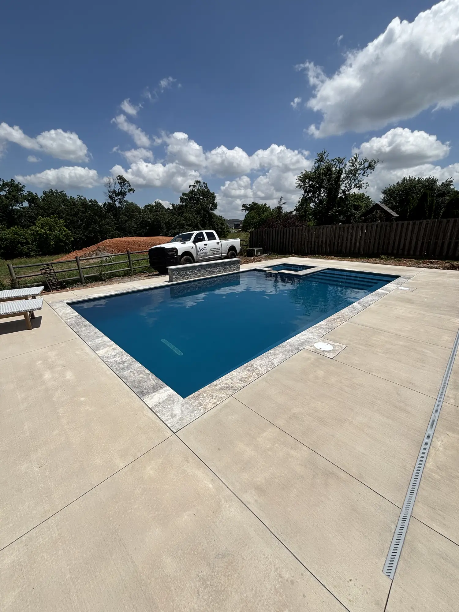 Finished rectangular pool under a clear blue sky in Northwest Arkansas