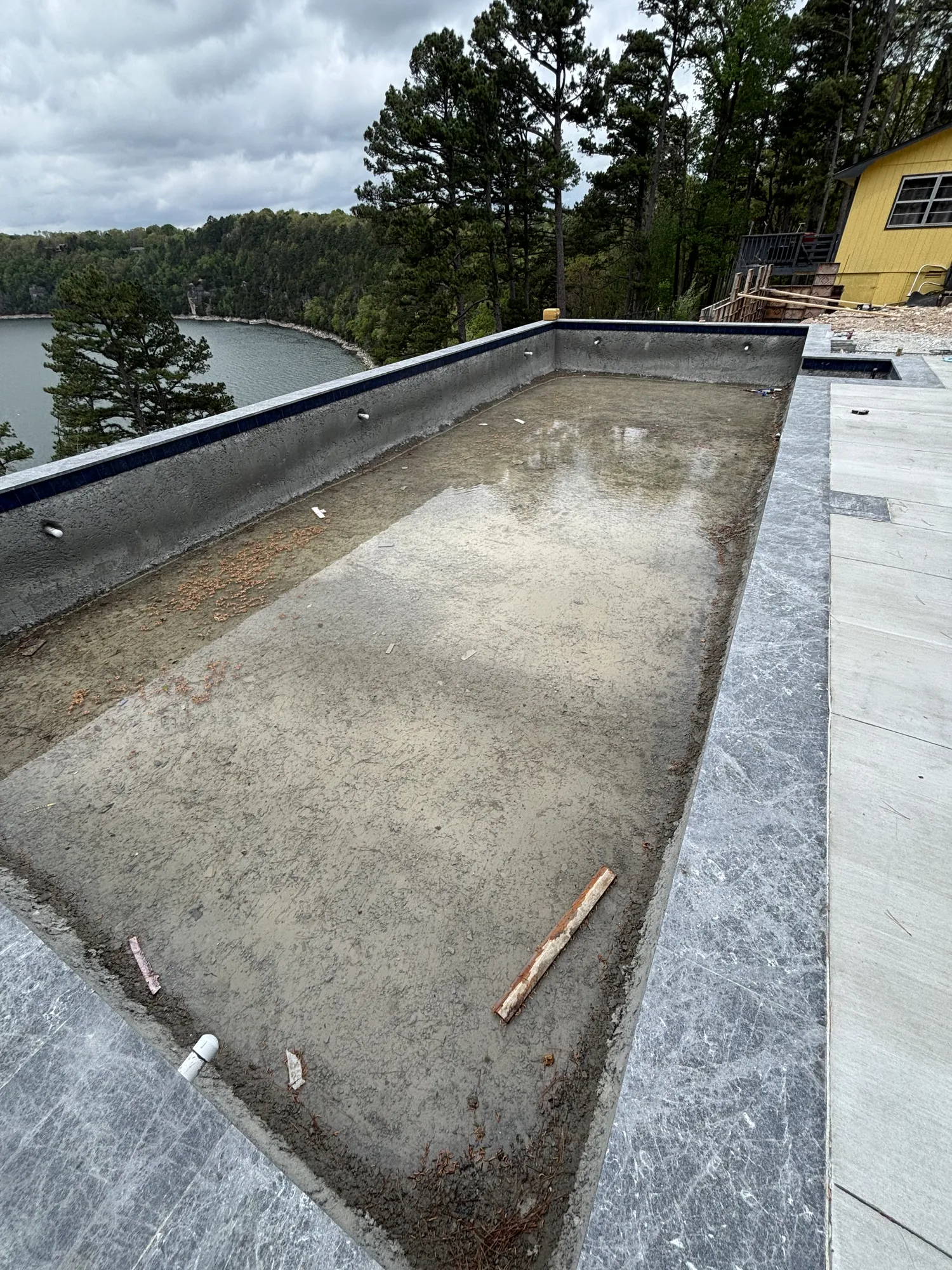Infinity-edge pool with marble coping at lakeside build in Northwest Arkansas