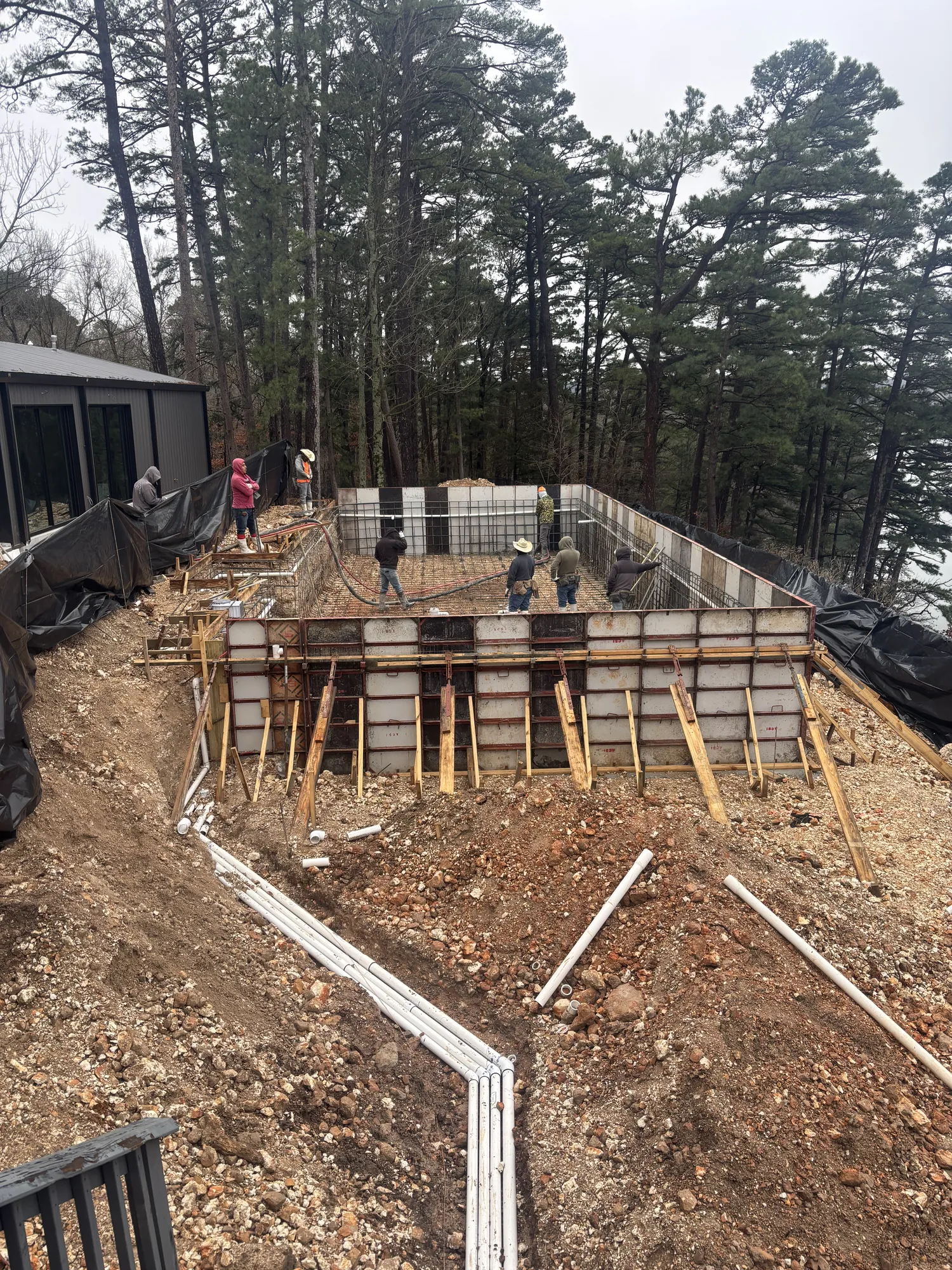 Crew constructing lakeside pool retaining walls in Northwest Arkansas