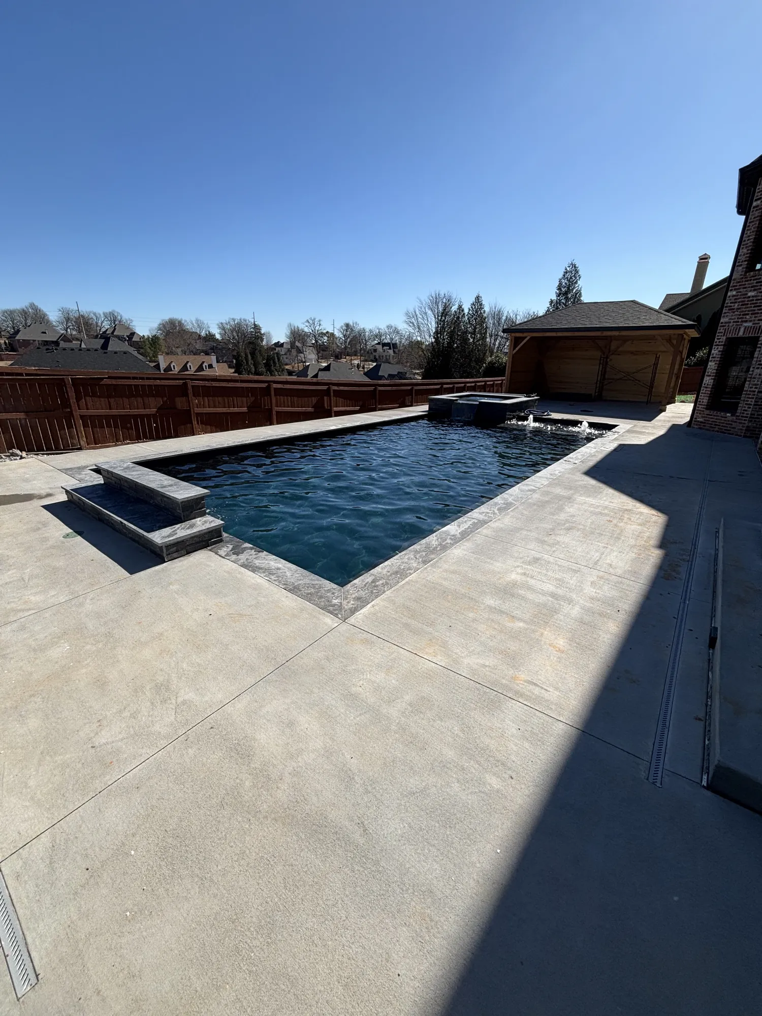 Finished pool and spa under blue sky in Northwest Arkansas