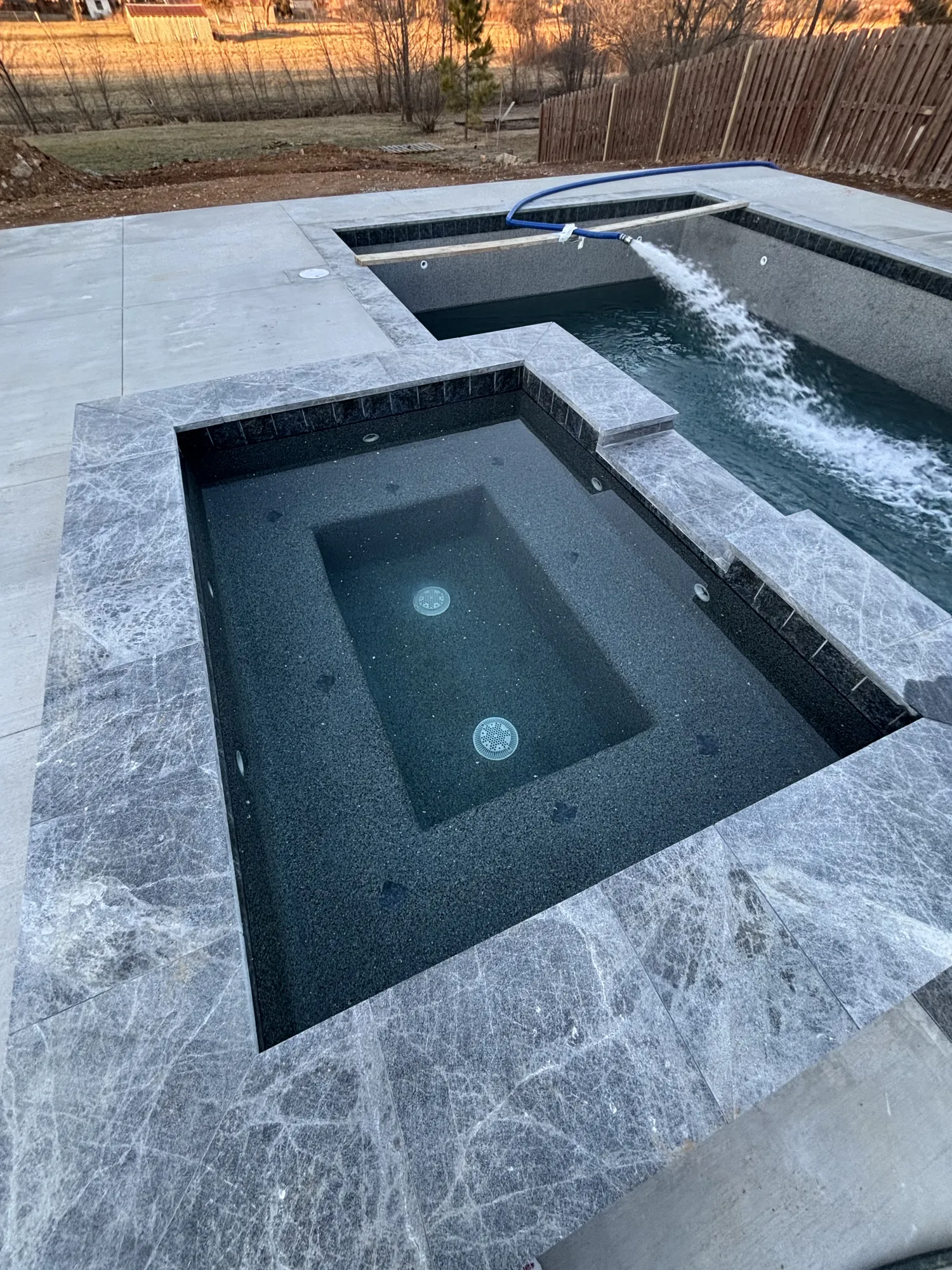 Raised spa with tiled spillway in Northwest Arkansas