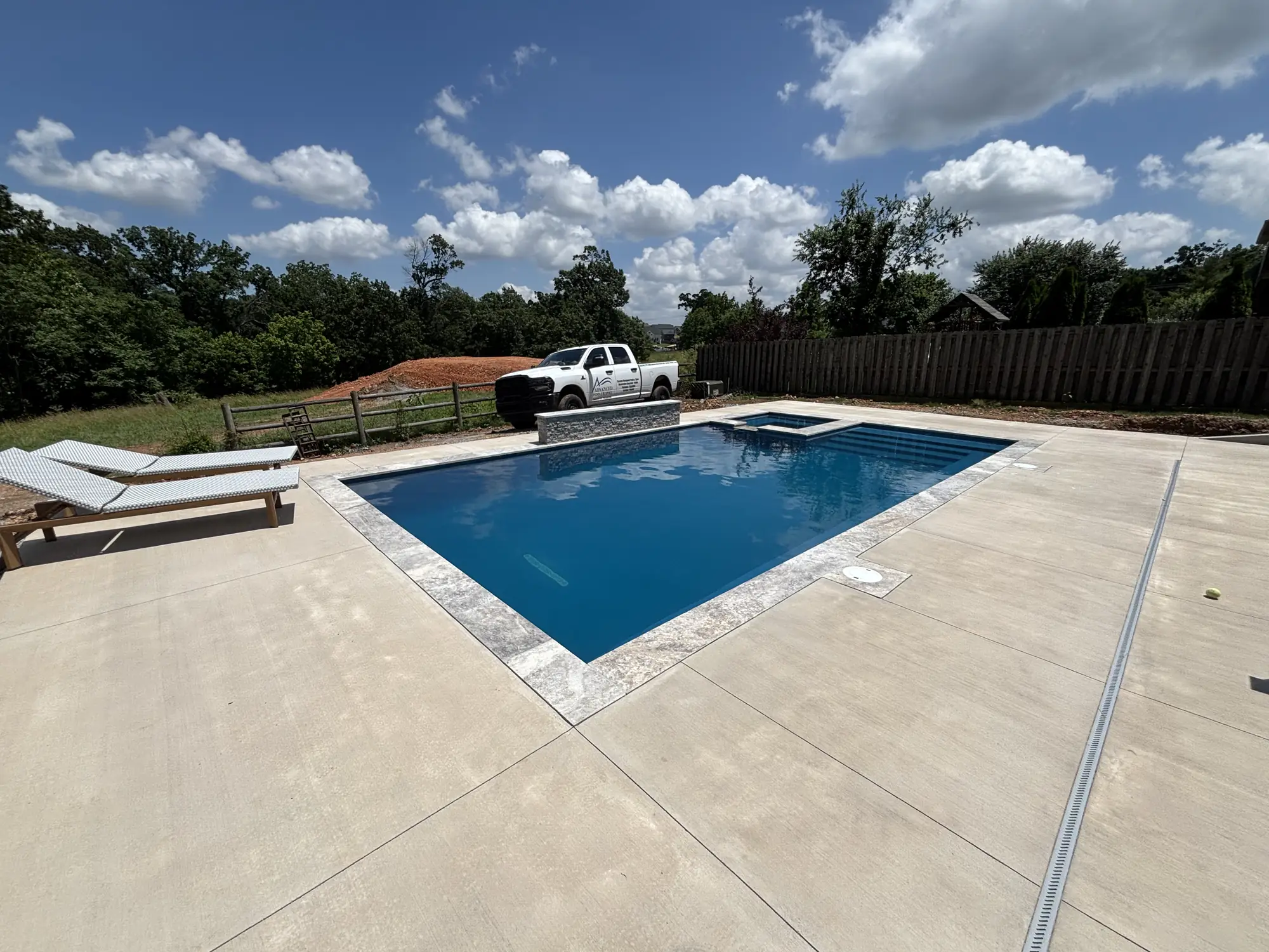 Rectangular pool with raised spa and poolside loungers in Northwest Arkansas