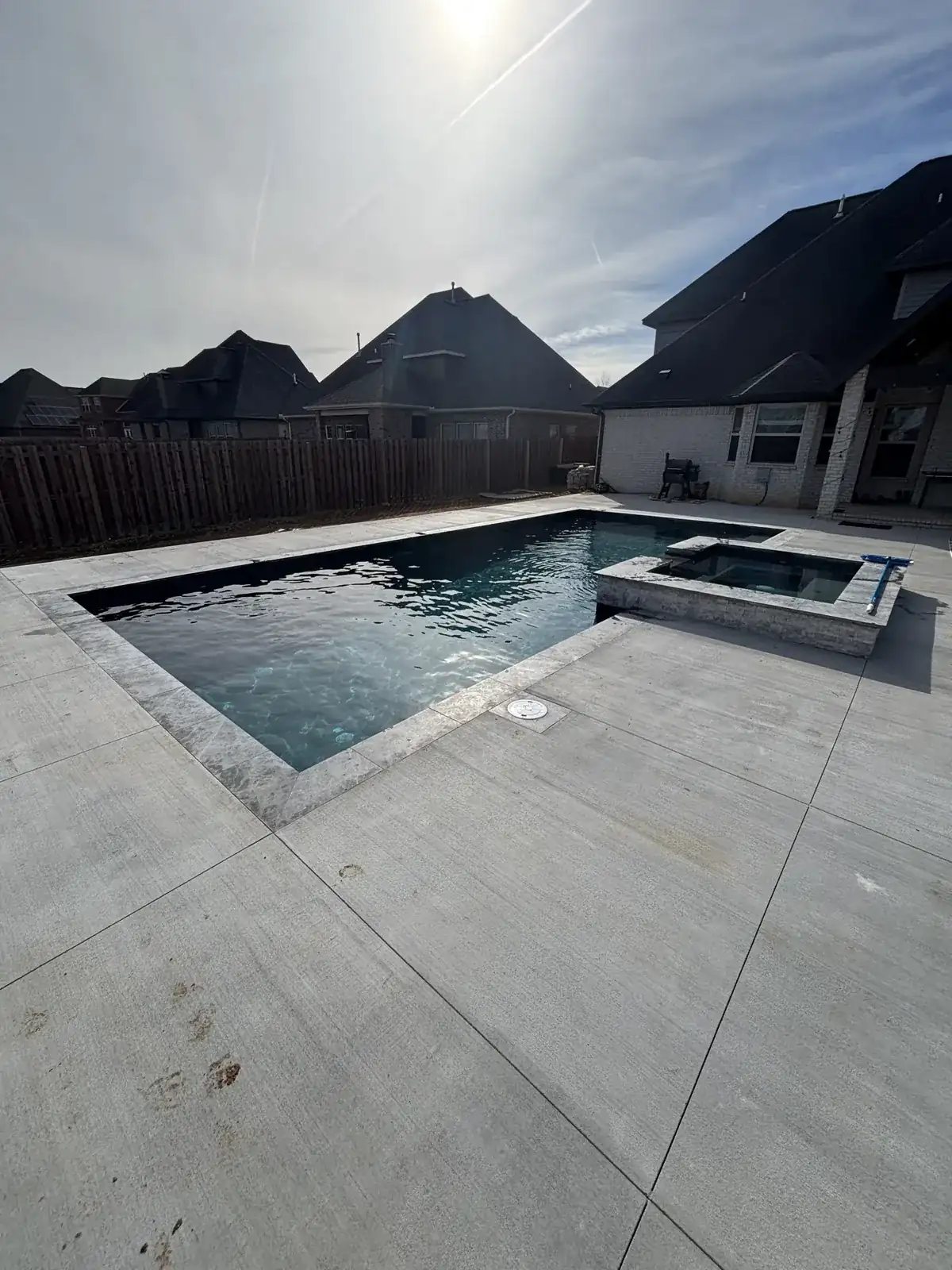 In-ground pool with raised spa and marble decking in Northwest Arkansas