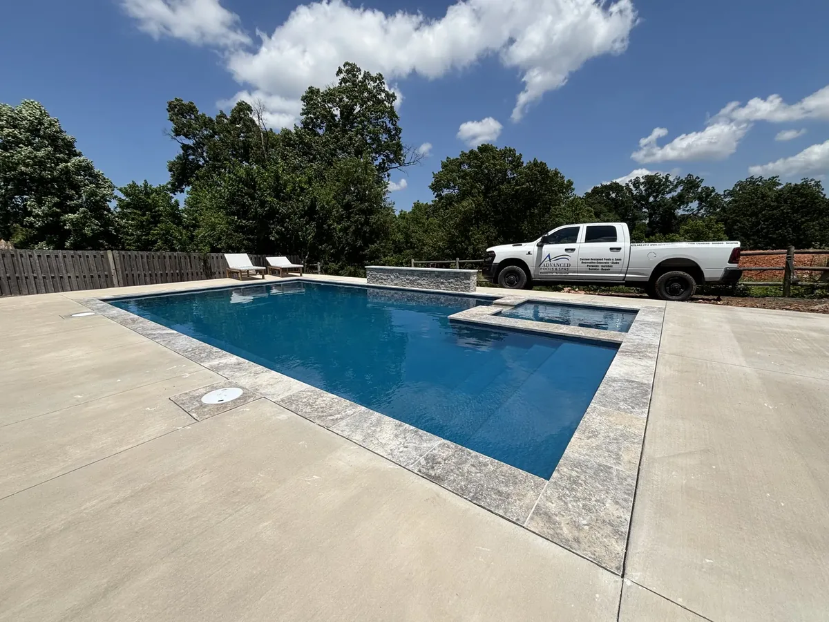 Rectangular pool and raised spa with travertine coping in Northwest Arkansas